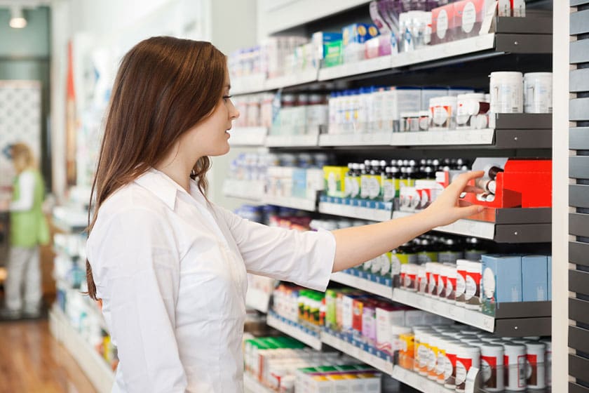 Woman looking at the medicine on a shelf in a pharmacy
