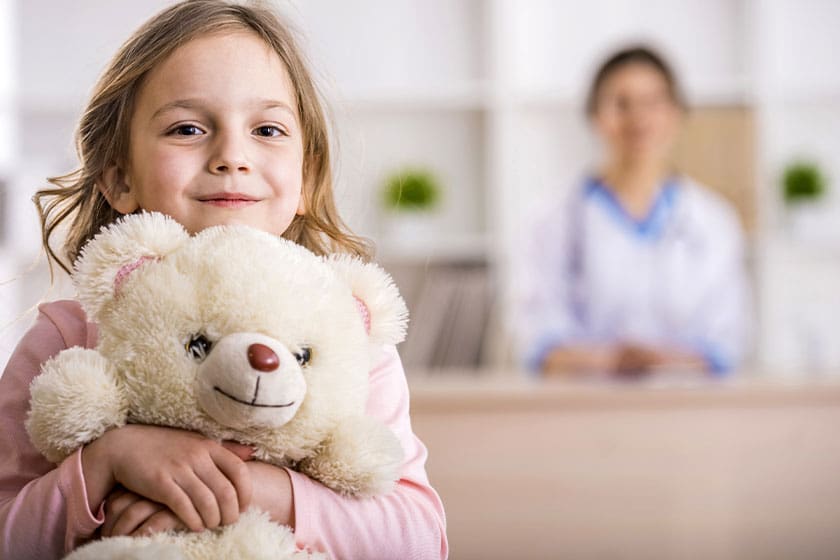 Young girl hugging a teddy bear at the pharmacy
